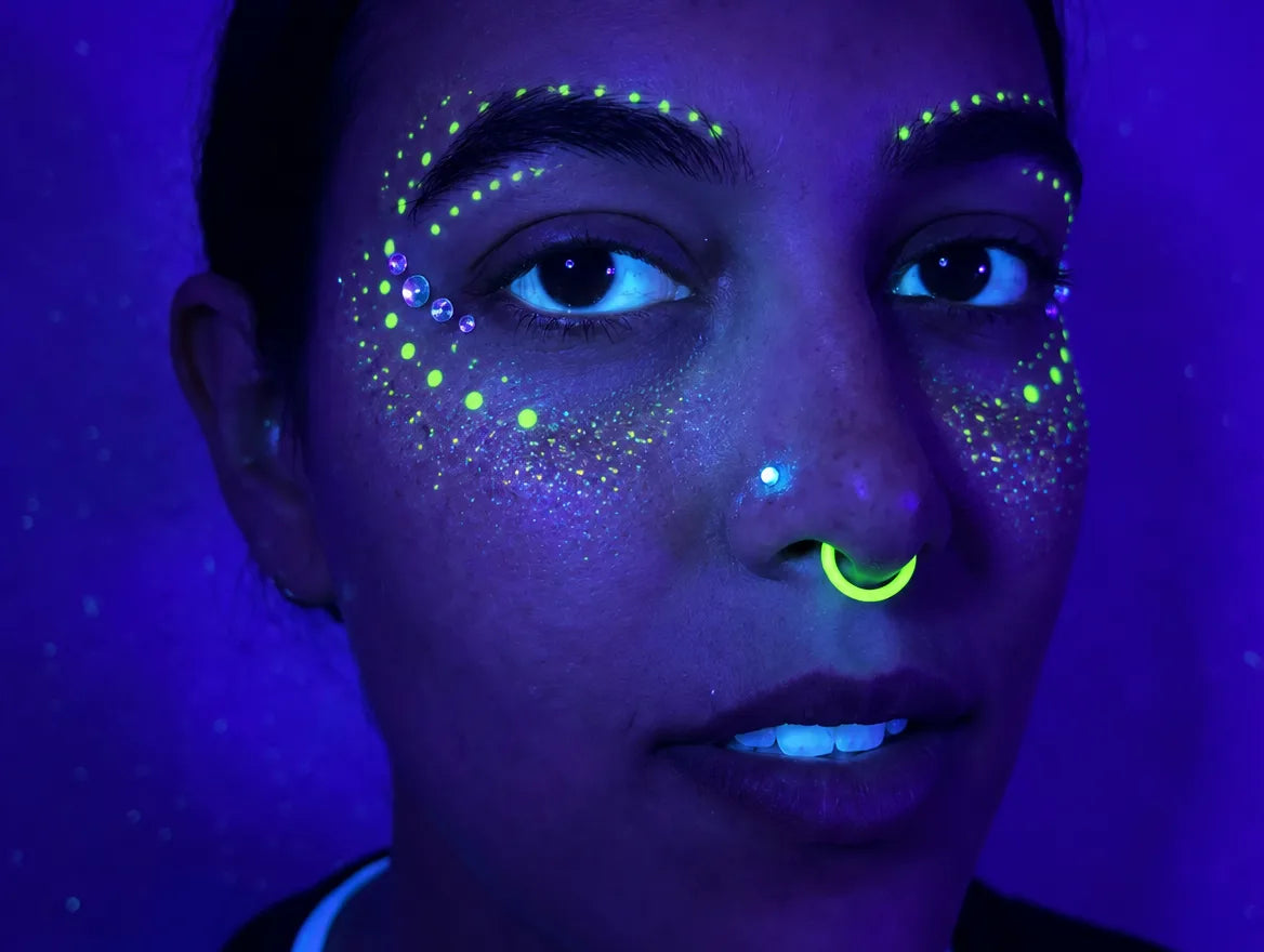 A yellow ring glowing under blacklight, with glowing rave face makeup