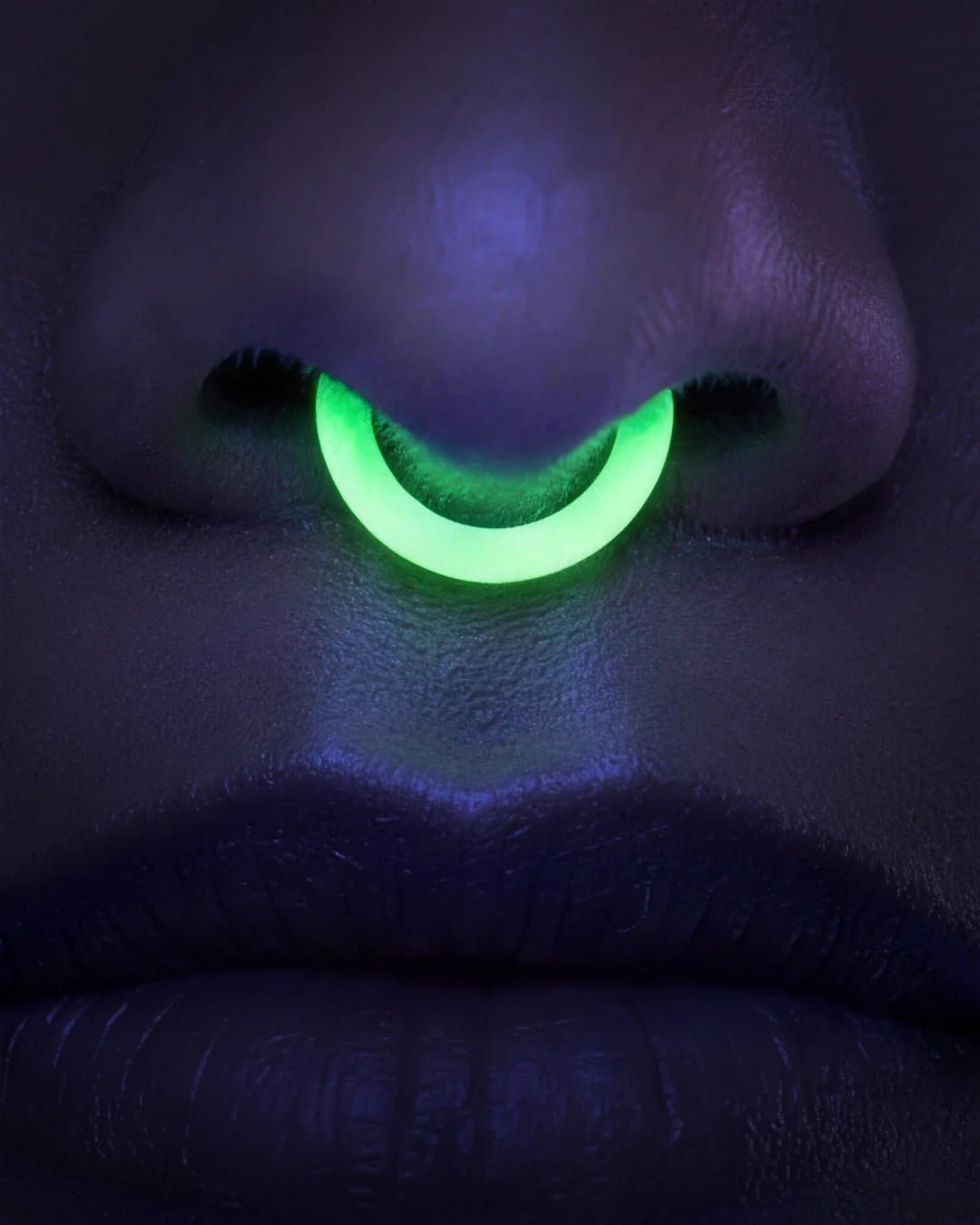 A ring glowing green under blacklight, the rest of the frame dark